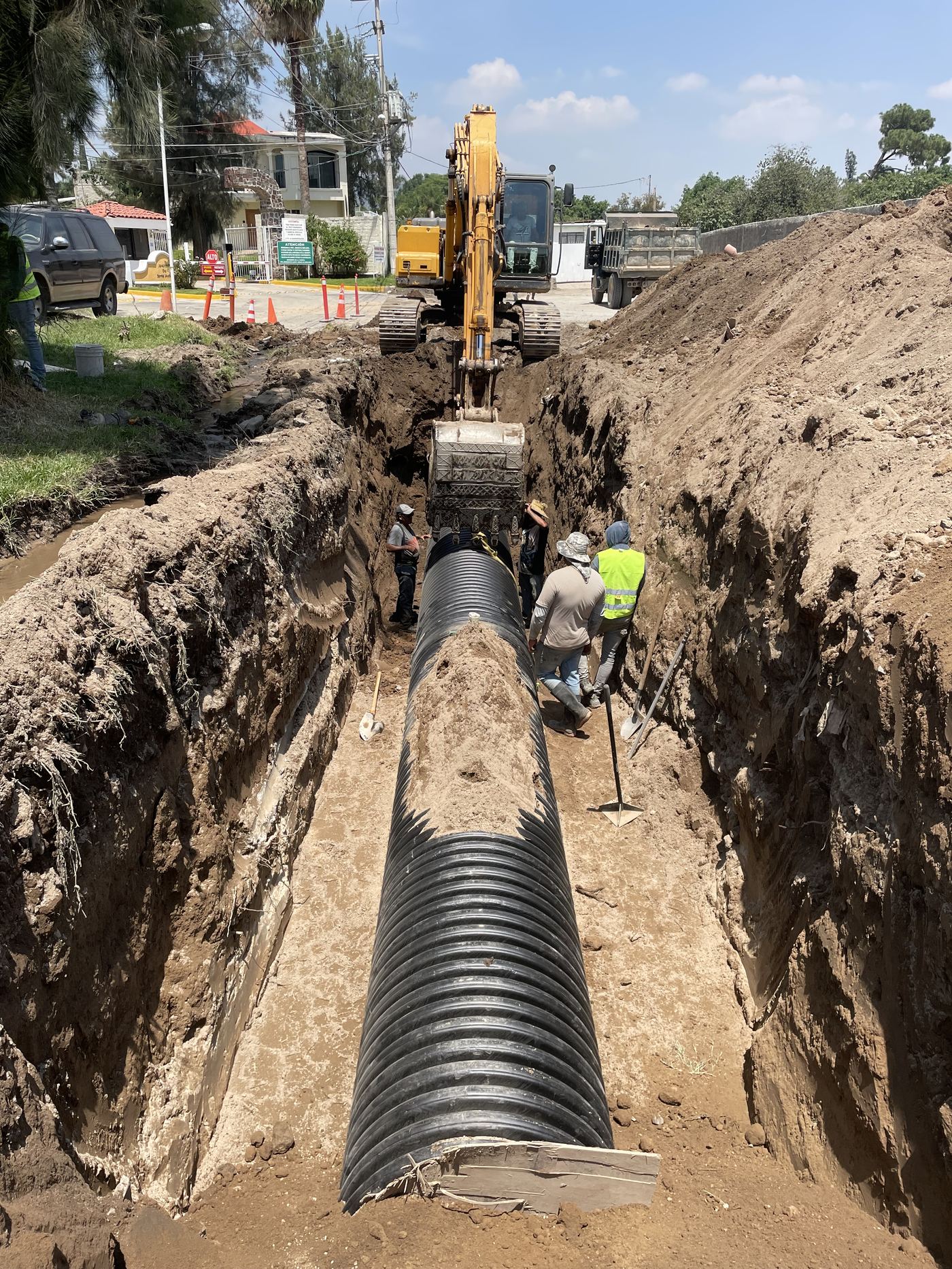 Tendido de tubería pluvial en zanja con excavadora